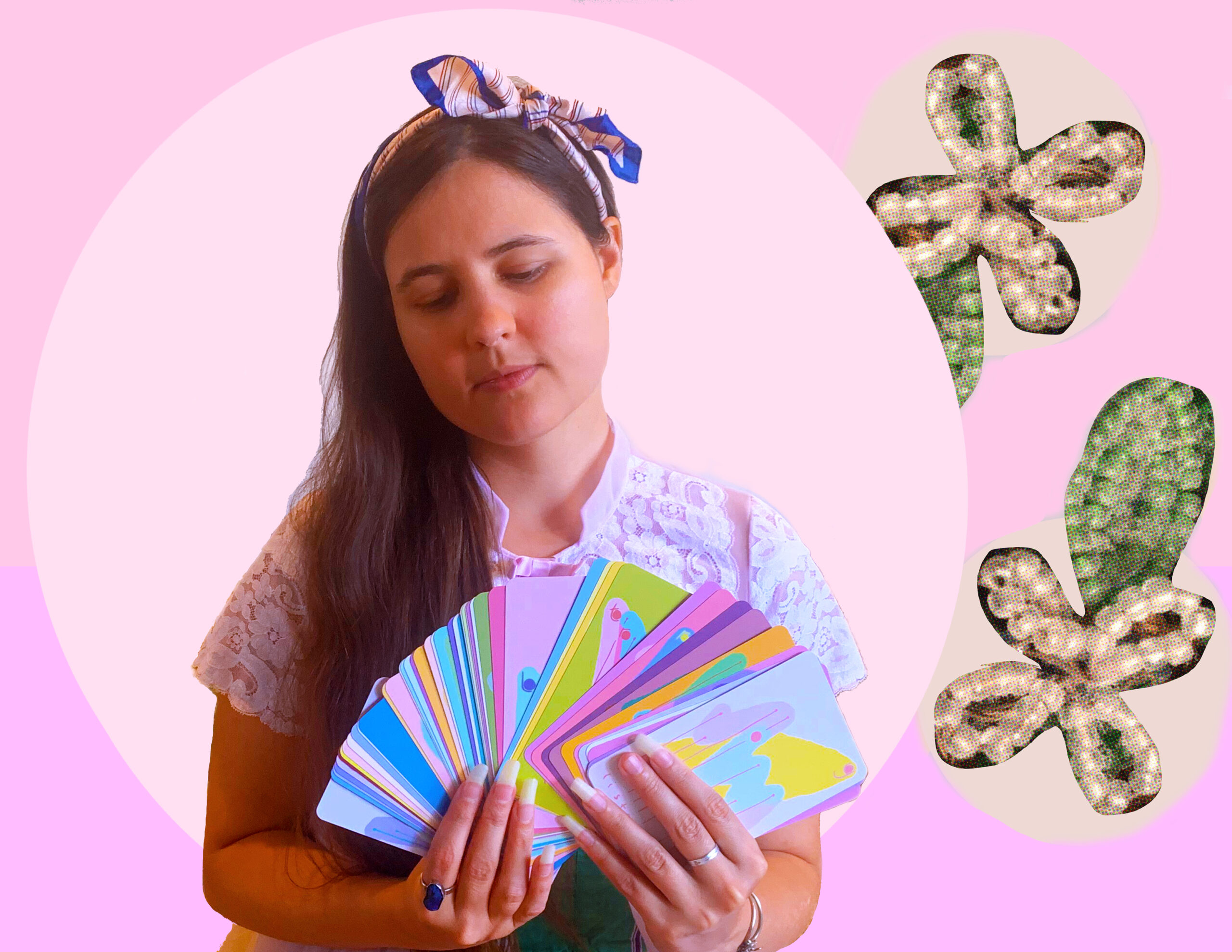 Alexa Dexa (a white femme with long brown hair with a bow in it) holds their Sacrosanct Oracle//Composition Deck in their hands, pastel multicolored oracle messages facing out. A light pink circle surrounds them on a darker pink background. Two cream colored flowers with a single leaf made of beads float beside Alexa to the right.